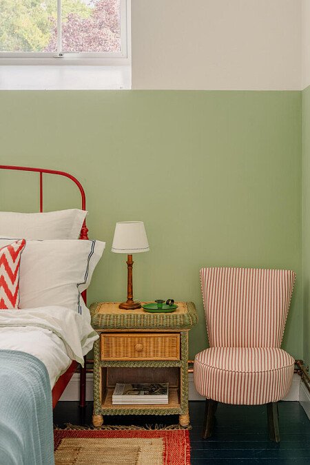 Red bed, striped chair, green bedroom